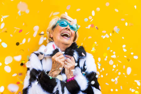 Happy and playful senior woman having fun - Portrait of a beautiful lady above 70 years old with stylish clothes, concepts about senior peopleの写真素材