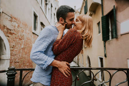 Beatiful young couple having fun while visiting Venice - Tourists travelling in Italy and sightseeing the most relevant landmarks of Venezia - Concepts about lifestyle, travel, tourismの写真素材