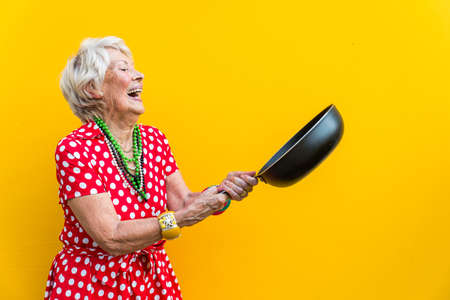 Happy and playful senior woman having fun - Portrait of a beautiful lady above 70 years old with stylish clothes, concepts about senior peopleの写真素材