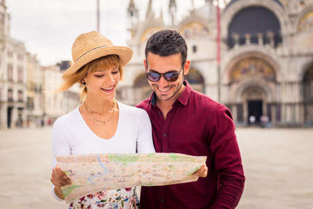 Beatiful young couple having fun while visiting Venice - Tourists travelling in Italy and sightseeing the most relevant landmarks of Venezia - Concepts about lifestyle, travel, tourismの写真素材