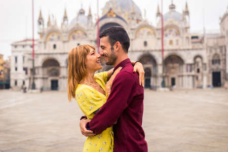 Beatiful young couple having fun while visiting Venice - Tourists travelling in Italy and sightseeing the most relevant landmarks of Venezia - Concepts about lifestyle, travel, tourismの写真素材