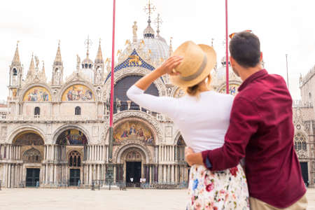 Beatiful young couple having fun while visiting Venice - Tourists travelling in Italy and sightseeing the most relevant landmarks of Venezia - Concepts about lifestyle, travel, tourismの写真素材