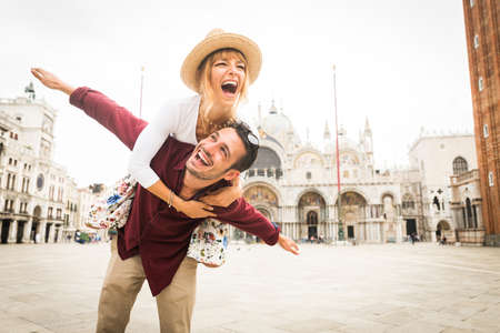 Beatiful young couple having fun while visiting Venice - Tourists travelling in Italy and sightseeing the most relevant landmarks of Venezia - Concepts about lifestyle, travel, tourismの写真素材