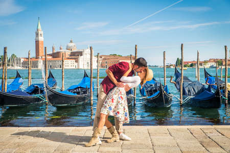 Beautiful young couple having fun while visiting Venice - Tourists traveling in Italy and sightseeing the most relevant landmarks of Venezia - Concepts about lifestyle, travel, tourismの写真素材