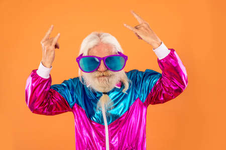 Fashionable grandfather posing with funny futuristic clothes. Senior man portraits on colored backgroundの写真素材