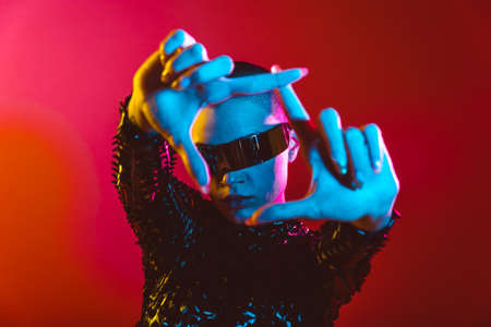 Modern beauty portrait. Young woman with shaved head. Colored gel fashion lookの写真素材