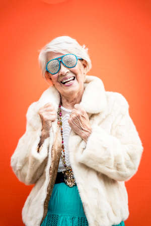 Funny grandmother dancing on colored backgroundの写真素材
