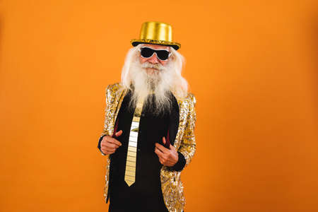 Senior man with eccentric look - 60 years old man having fun, portrait on colored background,...