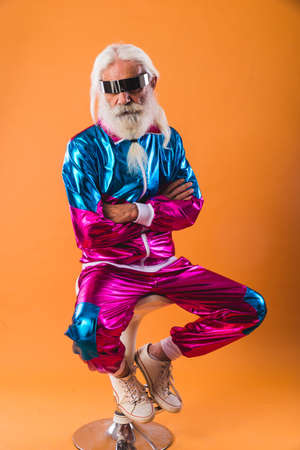 Senior man with eccentric look - 60 years old man having fun, portrait on colored background, concepts about youthful senior people and lifestyleの写真素材