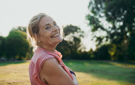 Happy grandmother enjoying sunset in the garden