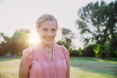 Happy grandmother enjoying sunset in the garden
