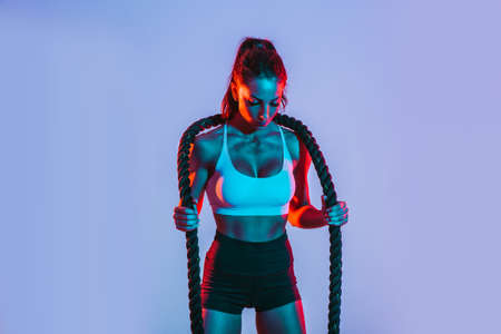 Fit woman training hard with ropes. Girl making exercizes in the gym. Concept about bodybuilding and lifestyleの写真素材
