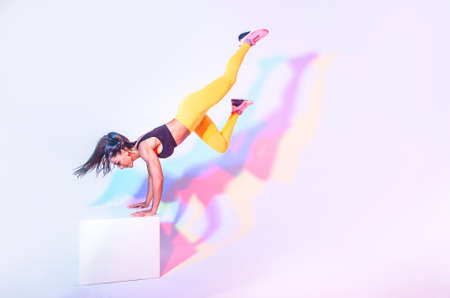 Beautiful woman training at home making exercizes on the workout box