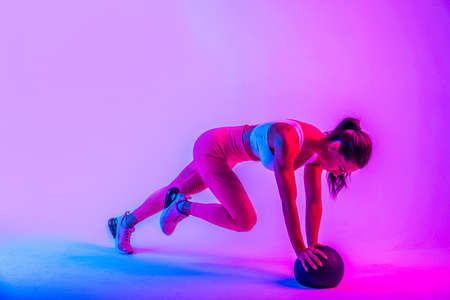 Athletic woman with fitness sportswear traning - Beautiful girl doing fitness in a studioの写真素材