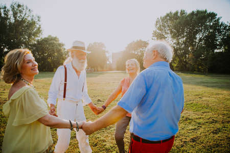 Group of youthful seniors having fun outdoors - Four pensioners bonding outdoors, concepts about lifestyle and elderlyの写真素材