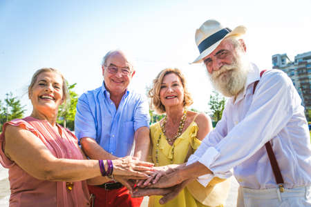 Group of youthful seniors having fun outdoors - Four pensioners bonding outdoors, concepts about lifestyle and elderlyの写真素材