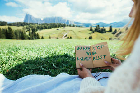 Happy couple on vacation on the italian dolomites mountains. Young man and woman reading their...