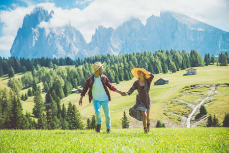 Happy couple on vacation on the italian dolomites mountains. Young man and woman making activities...