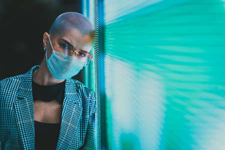 Image of a beautiful young woman posing against a led panel. teenager with alternative look and gray...