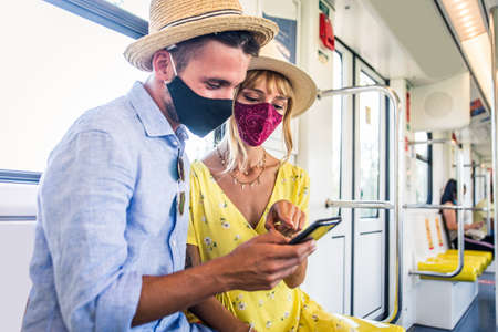 Beautiful couple driving on a subway wagon during covid-19 pandemic, concepts about lifestyle, transportation and social distancingの写真素材