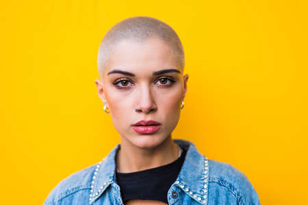 Pretty girl with stylish clothes posing - Beautiful woman with shaved head portraitの写真素材