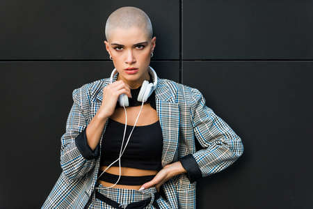 Pretty girl with stylish clothes posing - Beautiful woman with shaved head portraitの写真素材