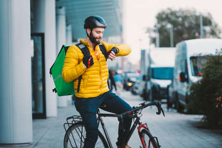Food delivery rider on his bicycle. Image of a middle age man at work in the city center. Delivering...