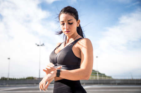 Female urban runner training in the city center. Beautiful woman doing sport in the early morningの写真素材