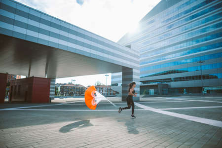 Female urban runner training in the city center. Beautiful woman doing sport in the early morningの写真素材