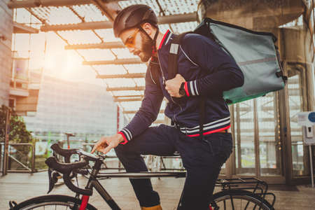 Food delivery service, rider delivering food to clints with bicycle - Concepts about transportation, food delivery and technologyの写真素材