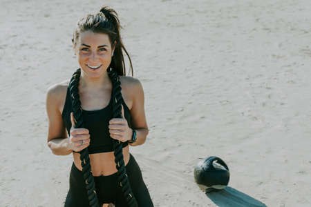 Functional training workout on the beach, fit and athletic woman doing sport outdoors - Concepts about lifestyle, sport and healthy lifestyleの写真素材