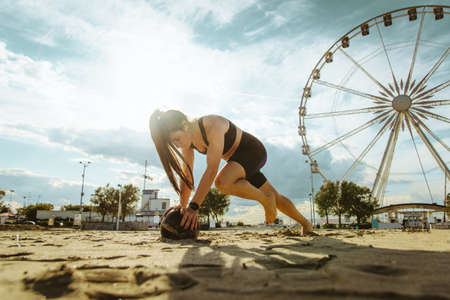 Functional training workout on the beach, fit and athletic woman doing sport outdoors - Concepts about lifestyle, sport and healthy lifestyleの写真素材