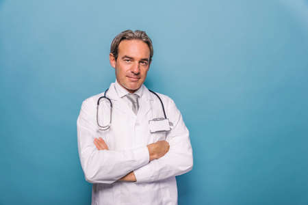 Handsome doctor portrait on blue background, concepts about healthcare and medicalの写真素材