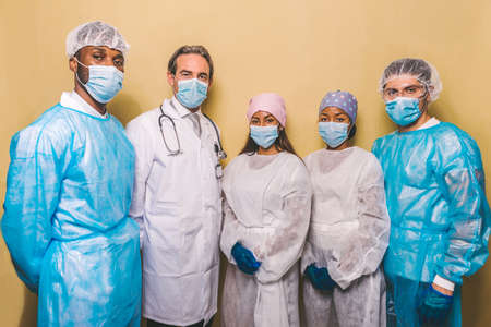 Team of doctors and nurses wearing disposable protection suits and face masks for fighting Covid-19 (Corona virus) - Medical team portrait during coronavirus pandemic quarantine, concepts about healthcare and medicalの写真素材