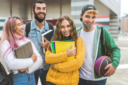 Happy young people meeting outdoors and wearing face masks during covid-19 pandemic - Group of...
