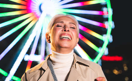 Pretty senior woman having fun at amusement park, concepts about elderly and lifestyle