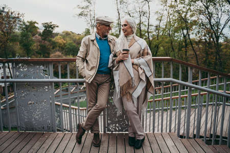 Happy senior couple walking outdoor in the park. Spending time together in a beautiful day of autumn.の写真素材