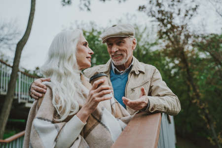 Happy senior couple walking outdoor in the park. Spending time together in a beautiful day of autumn.の写真素材