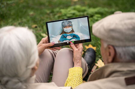 Seniors talking with their relatives through a video chat on the computerの写真素材