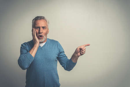 Handsome senior man isolated on gray background. Concept about the third age and seniority
