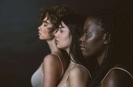 Three girls from different ethnicity posing in the studio for a "body positivity" photo sessionの写真素材
