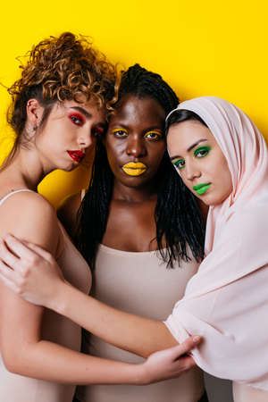 Three girls from different ethnicities posing in the studio for a "body positivity" photo sessionの写真素材