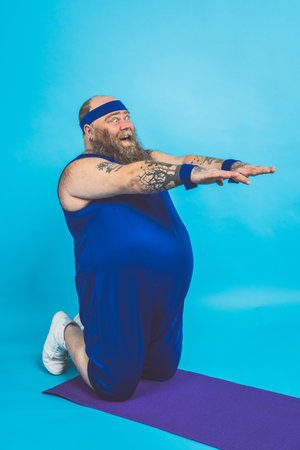 Hipster man with tattoos doing sport and exercises in the morningの写真素材