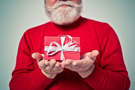 Funny senior man posing as santa claus in a photoshooting. Happy hipster doing funny expressions. Concept about people and christmasの写真素材