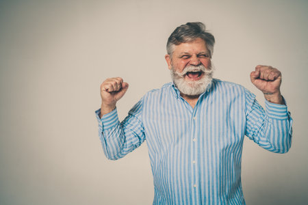 Funny senior man posing in a photoshooting. Happy hipster doing funny expressions. Concept about people and lifestyle.の写真素材