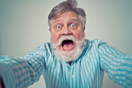 Funny senior man posing in a photoshooting. Happy hipster doing funny expressions. Concept about people and lifestyle.の写真素材