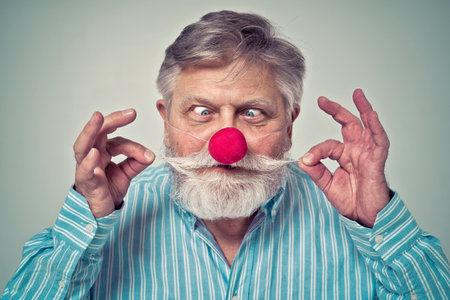 Funny senior man posing in a photo shooting. Happy hipster doing funny expressions. Concept about people and lifestyle.の写真素材