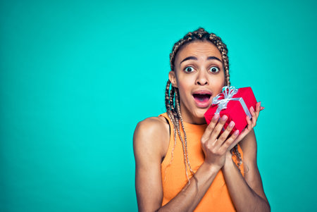 Beautiful girl with pigtails making shopping. Young adult posing on a blue colored backgroundの写真素材
