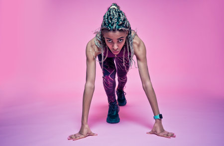 Beautiful girl doing exercises and sport. Posing on a pink colored backgroundの写真素材