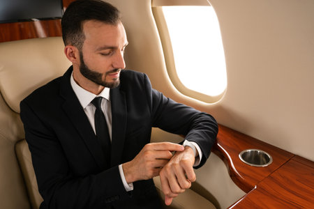 Handsome businessman wearing elegant suit flying on exclusive private jet - Successful entrepreneur...